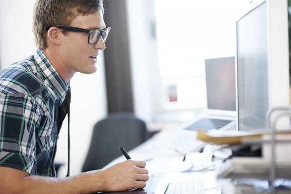 young man writing his resume on his computer