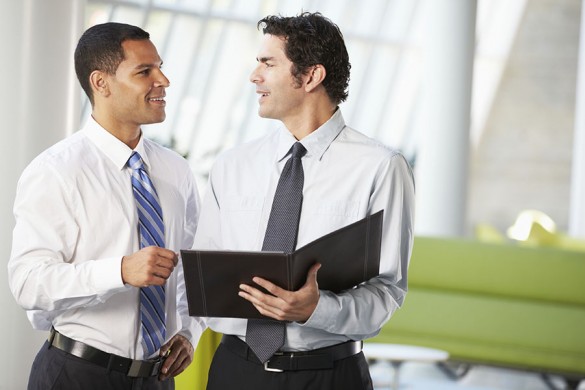 Two Businessmen Having Informal Meeting In Modern Office